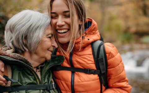 Nuorempi ja iäkkäämpi nainen halaavat retkipolulla.